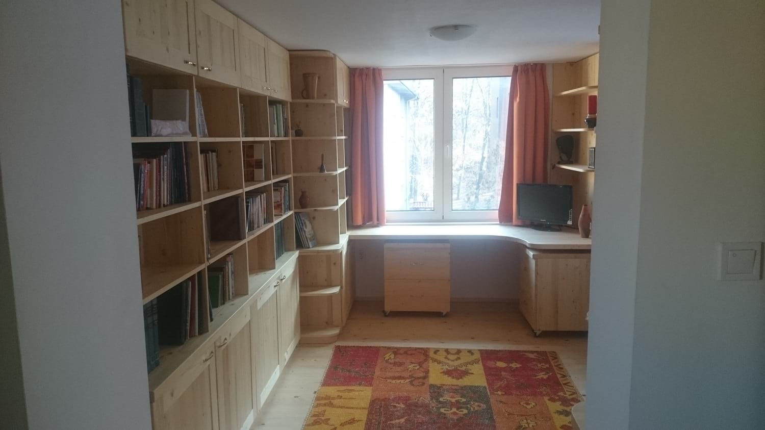 ъглово дървено бюро за детска стая с две шкафчета на колелца и библиотека на стената